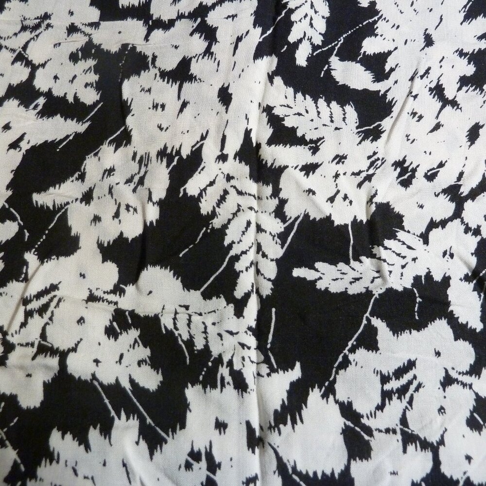 Fabric with white flower and fern pattern on a black background